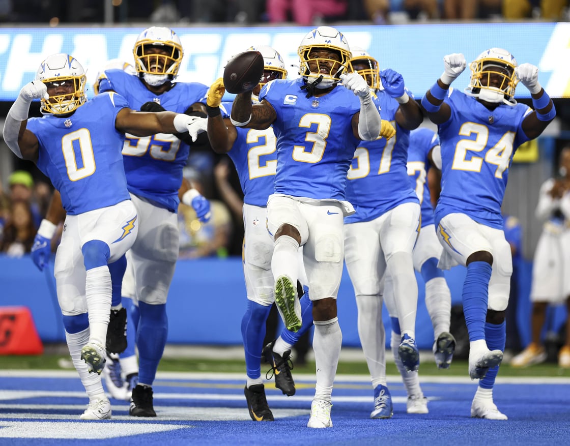 Los Angeles Chargers teammates celebrate after an interception.