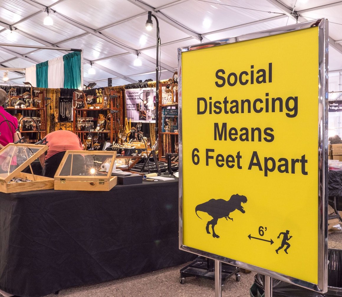 yellow social distancing sign in a convention area