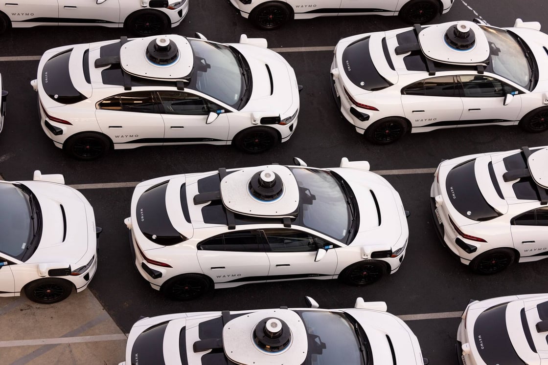 Waymo vehicles parked at a storage facility.