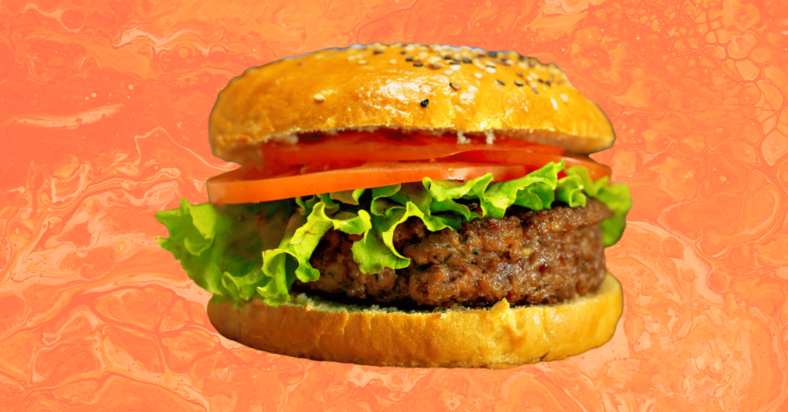 A veggie burger against an orange background.