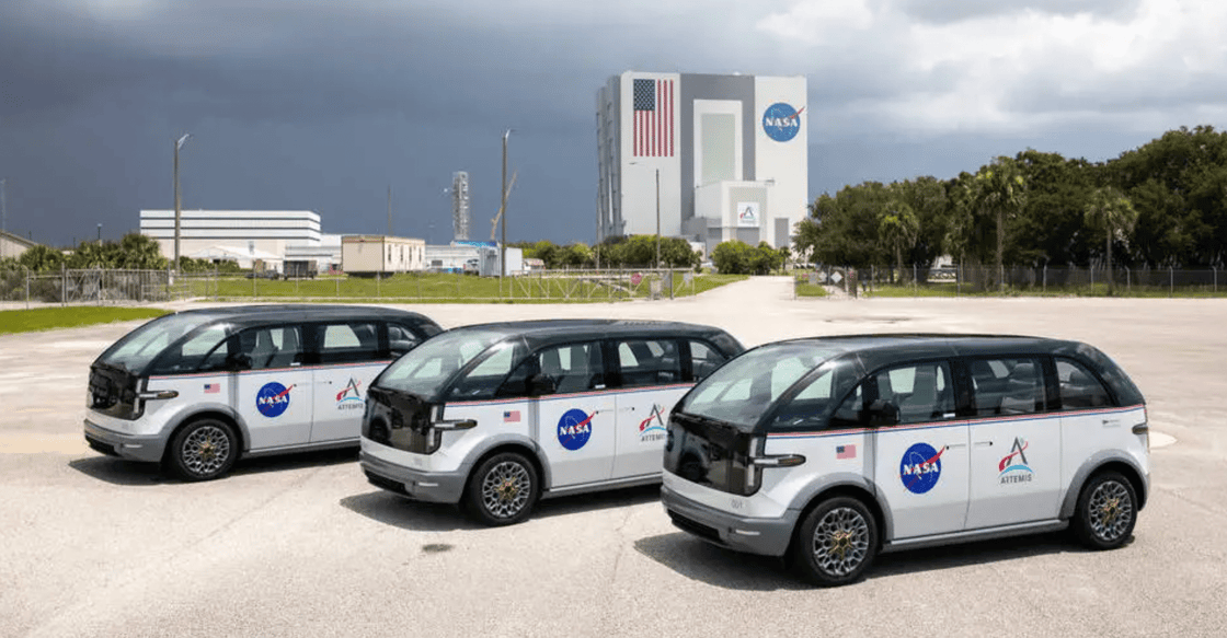 Three crew transportation vehicles parked in front of NASA’s Kennedy Space Center.